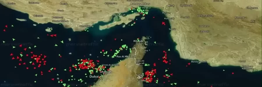 A marine traffic map of the Strait of Hormuz showing numerous red and green vessels.